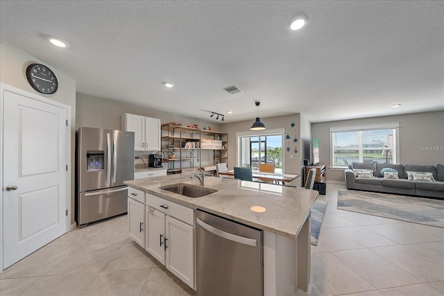 kitchen featuring stainless steel appliances, white cabinets, a kitchen island with sink, and sink