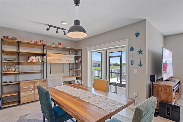 tiled dining area featuring a textured ceiling