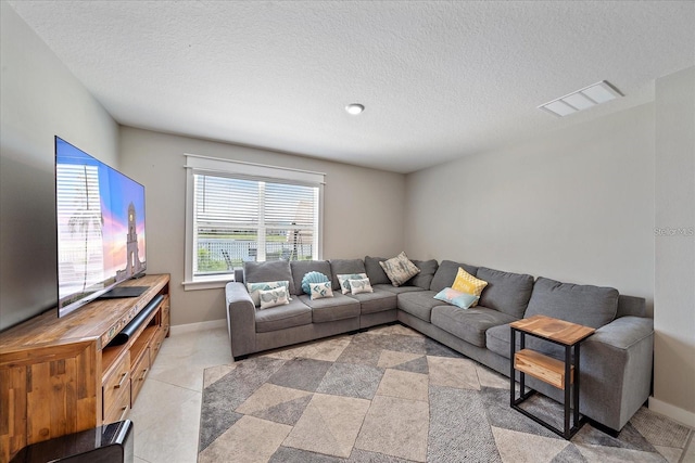 tiled living room featuring a textured ceiling