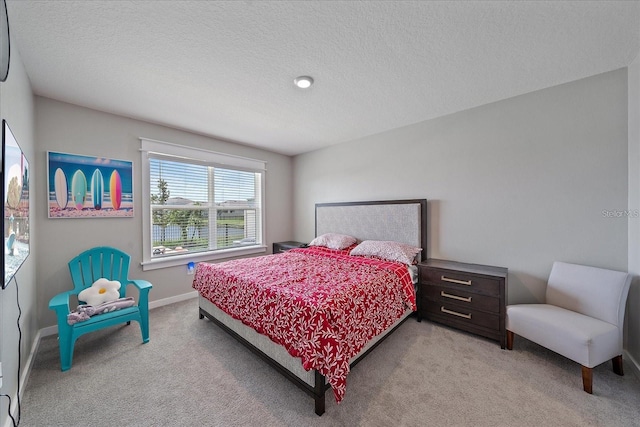 bedroom with a textured ceiling and light colored carpet