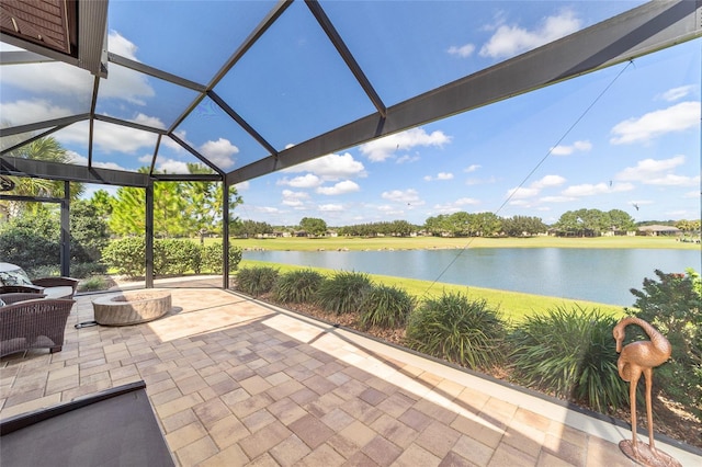 view of patio / terrace featuring a lanai and a water view