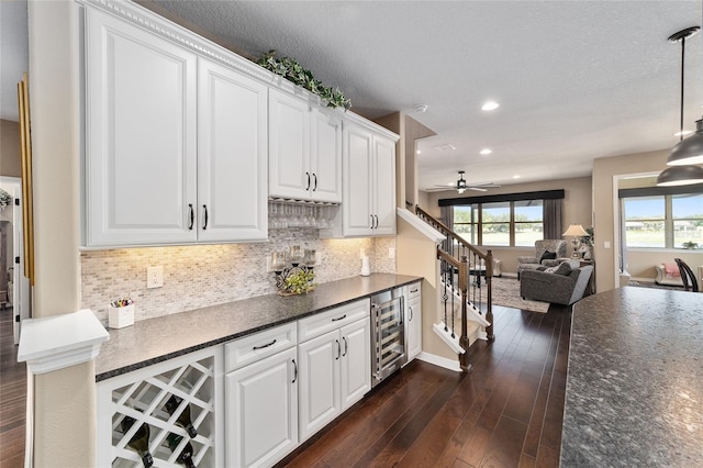 kitchen featuring wine cooler, white cabinets, and dark wood-type flooring