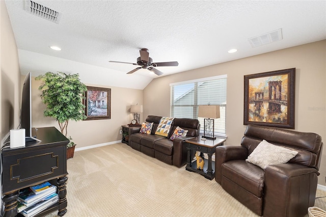 carpeted living room with ceiling fan, a textured ceiling, and vaulted ceiling