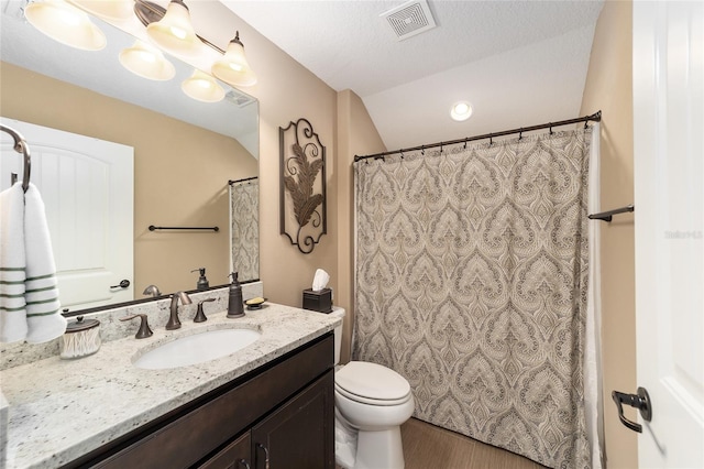 bathroom with vanity, a textured ceiling, wood-type flooring, toilet, and lofted ceiling