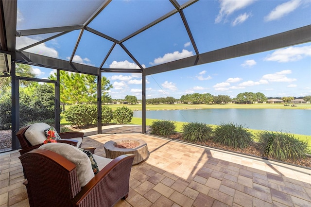 view of patio with glass enclosure, a water view, and an outdoor fire pit