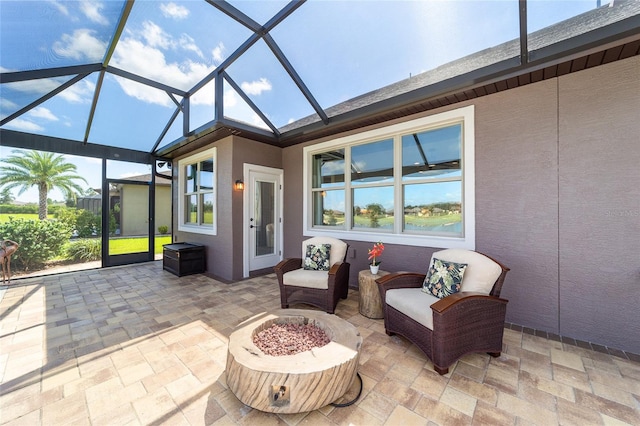 view of patio / terrace featuring glass enclosure and an outdoor fire pit