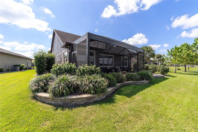 rear view of property featuring glass enclosure, central AC unit, and a lawn