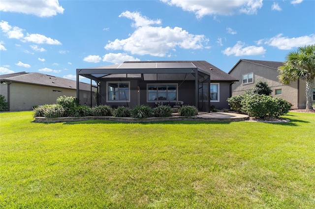 rear view of property with a yard and glass enclosure