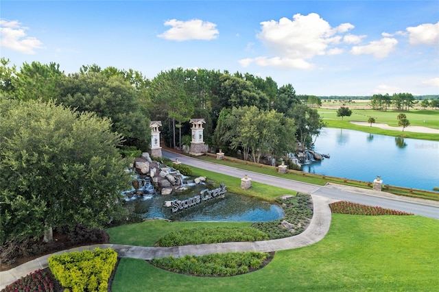 view of home's community featuring a lawn and a water view