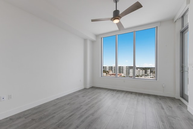 unfurnished room with light wood-type flooring and ceiling fan