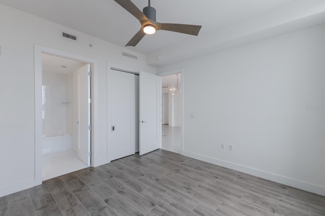 unfurnished bedroom with ceiling fan, a closet, light wood-type flooring, and ensuite bathroom