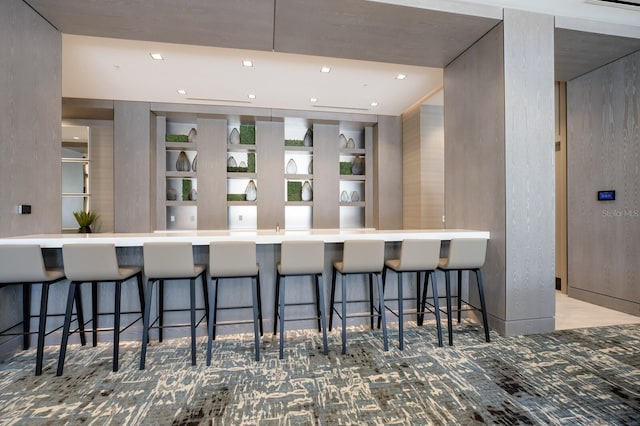 kitchen with a breakfast bar, carpet, and kitchen peninsula