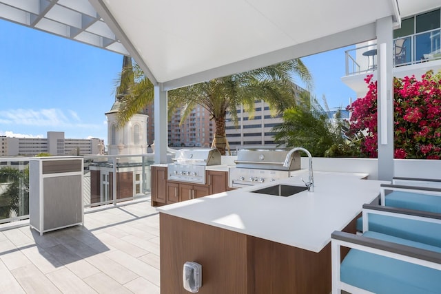 view of patio with sink, an outdoor kitchen, and a grill