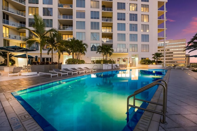 pool at dusk featuring a patio area