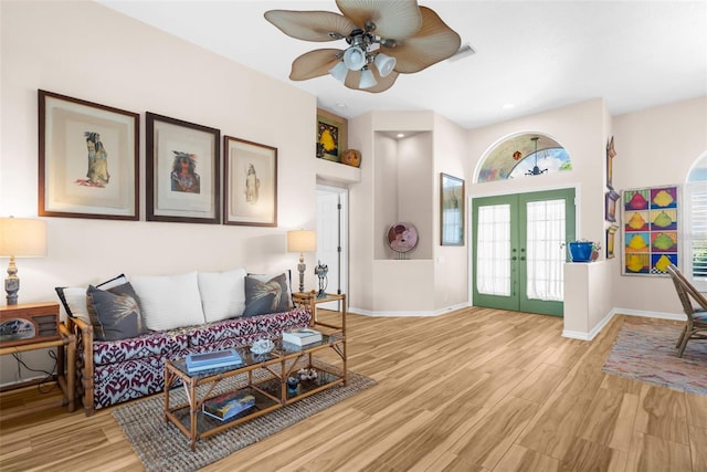 living room with ceiling fan, light hardwood / wood-style floors, and french doors