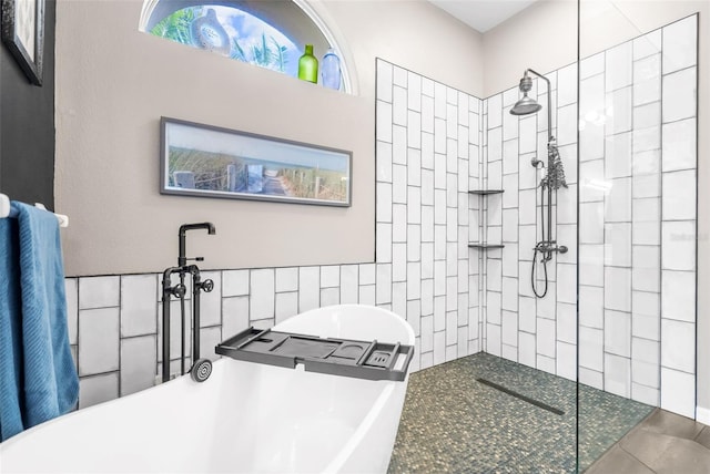 bathroom with tile patterned floors, tile walls, and shower with separate bathtub