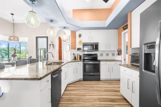 kitchen featuring pendant lighting, white cabinets, sink, dark stone countertops, and appliances with stainless steel finishes