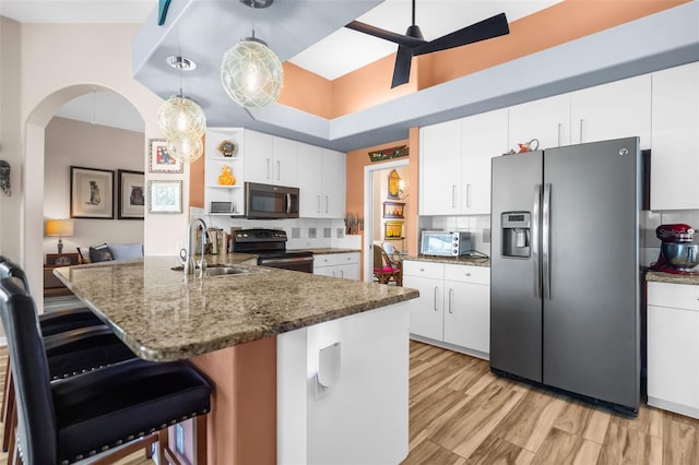 kitchen featuring decorative backsplash, appliances with stainless steel finishes, sink, pendant lighting, and white cabinets