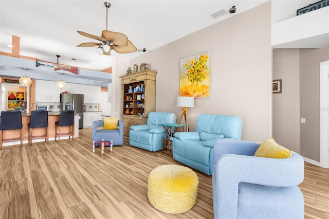 living room with ceiling fan and light wood-type flooring