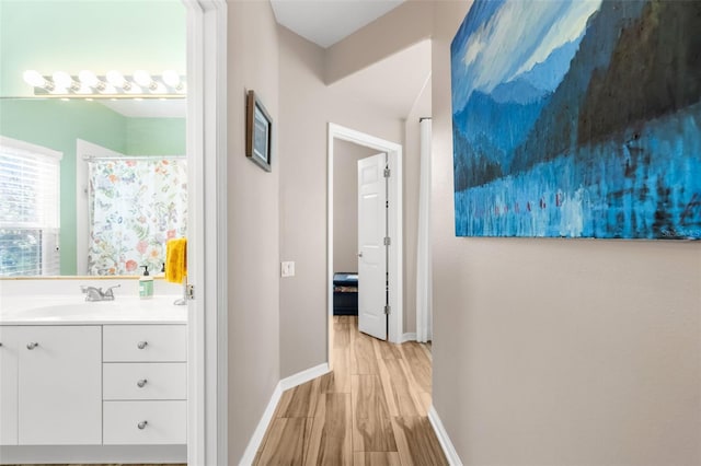 corridor featuring light hardwood / wood-style floors and sink