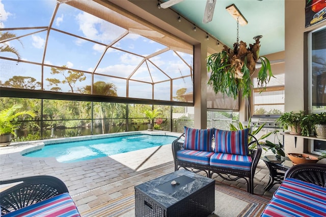 view of swimming pool featuring a lanai, ceiling fan, a patio area, and an outdoor hangout area