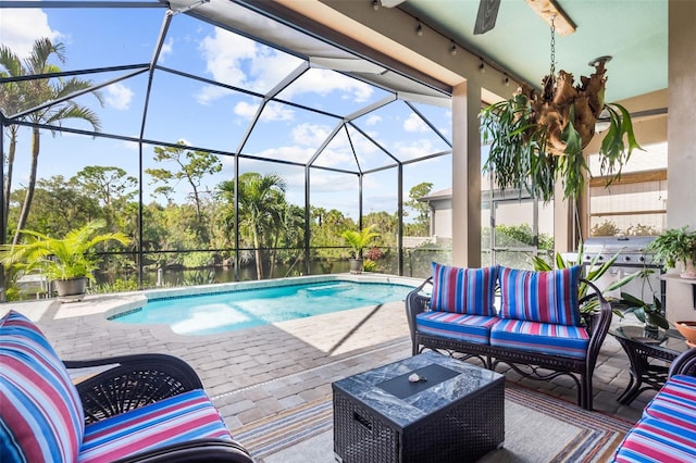 view of pool with outdoor lounge area, ceiling fan, a lanai, and a patio