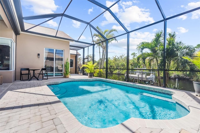 view of swimming pool featuring glass enclosure, a water view, and a patio