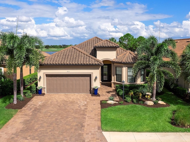 mediterranean / spanish-style home featuring a front yard and a garage