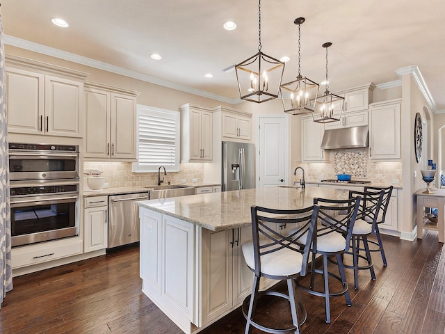 kitchen featuring a kitchen island with sink, stainless steel appliances, dark wood-type flooring, sink, and crown molding