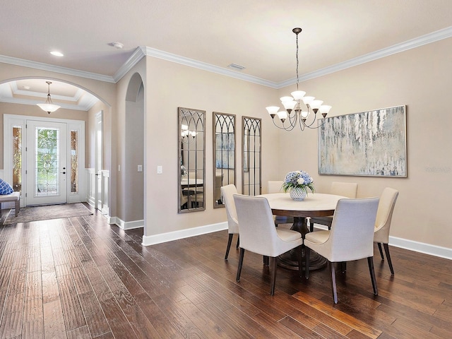 dining space with ornamental molding, a notable chandelier, and dark wood-type flooring