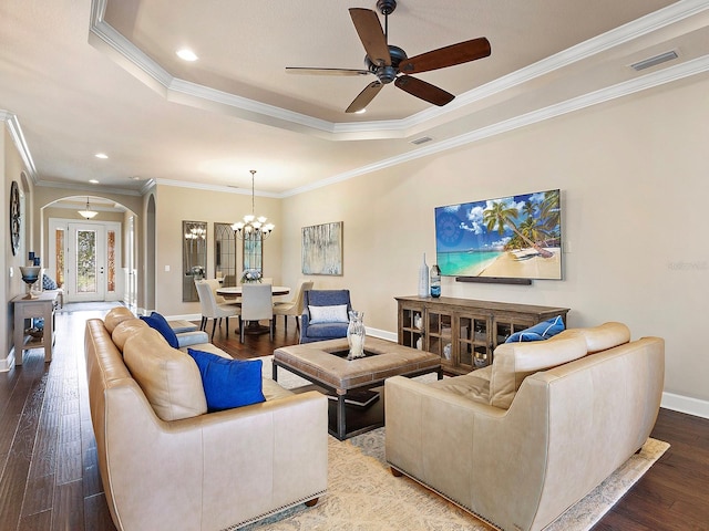 living room with ornamental molding, ceiling fan with notable chandelier, hardwood / wood-style floors, and a raised ceiling