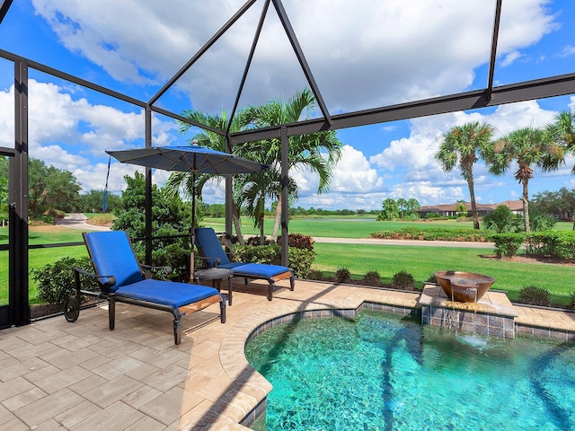 view of swimming pool with pool water feature, a patio, a yard, and a lanai