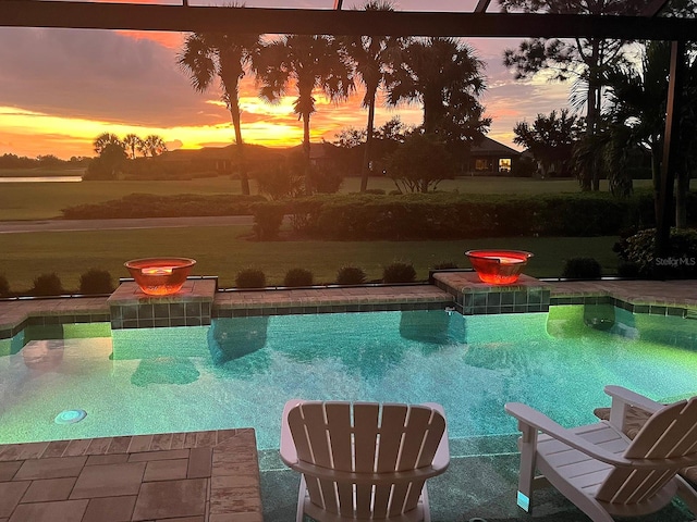 pool at dusk featuring a patio area