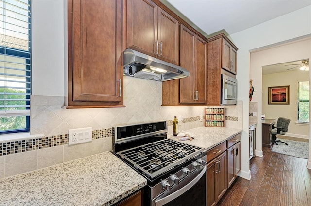 kitchen featuring dark hardwood / wood-style flooring, plenty of natural light, stainless steel appliances, and backsplash