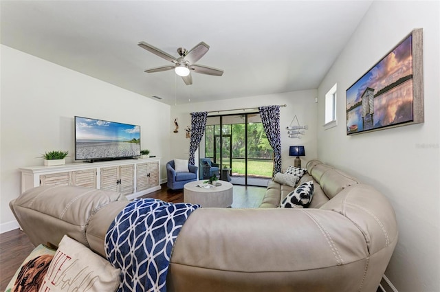 living room featuring ceiling fan and dark wood-type flooring