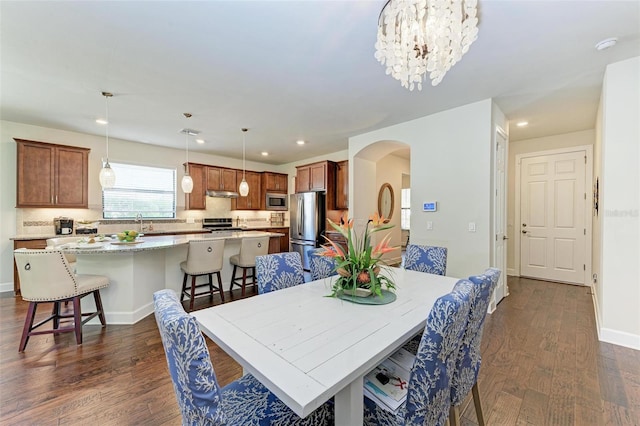 7572 Viola Loop, Lakewood Ranch, FL 34202 - dining space with arched walkways, dark wood finished floors, recessed lighting, and a chandelier