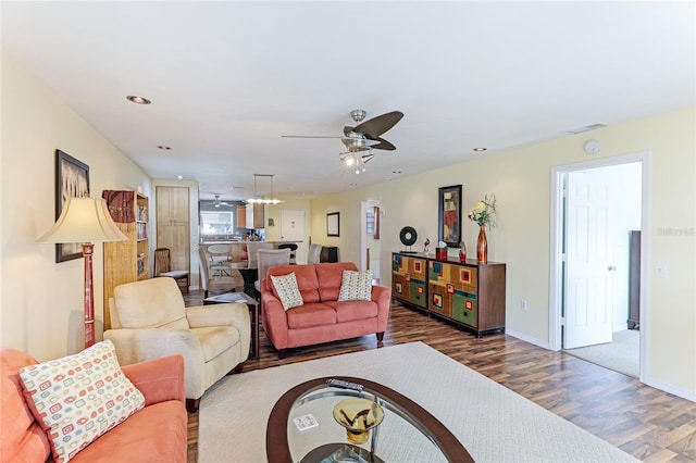 living room featuring ceiling fan and dark wood-type flooring