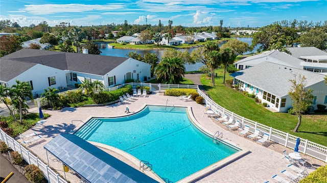 view of pool featuring a lawn, a water view, and a patio area