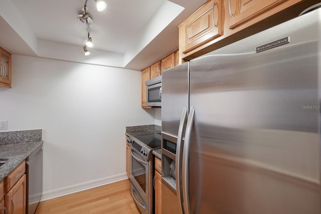 1542 Oak St Unit 6, Sarasota, FL 34236 - kitchen with stainless steel appliances, light wood-style flooring, dark stone counters, and rail lighting