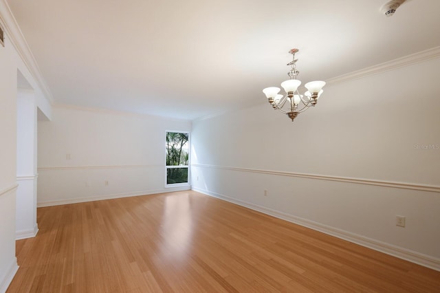 unfurnished room featuring ornamental molding, a chandelier, and light hardwood / wood-style floors