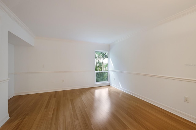 unfurnished room featuring hardwood / wood-style floors and crown molding