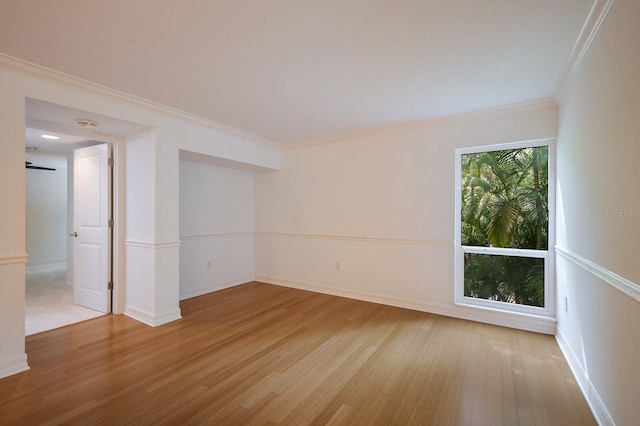 empty room with light hardwood / wood-style floors and ornamental molding