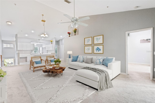 carpeted living room with high vaulted ceiling