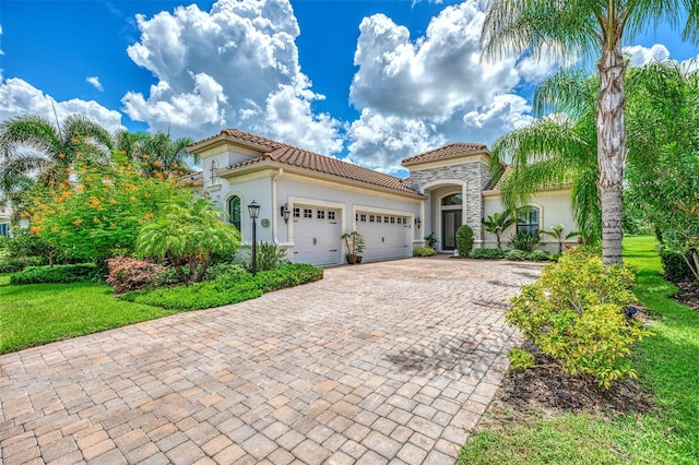 mediterranean / spanish home with a front yard and a garage