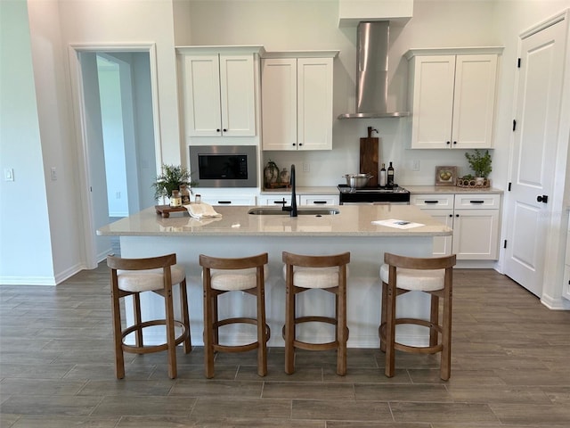11709 Capstan Pl, Parrish, FL 34219 - kitchen with a sink, wall chimney exhaust hood, appliances with stainless steel finishes, dark wood finished floors, and a breakfast bar