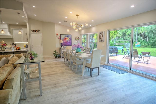 dining area featuring a notable chandelier, lofted ceiling, and light hardwood / wood-style floors