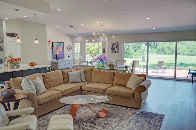 living room featuring a chandelier, vaulted ceiling, and hardwood / wood-style flooring