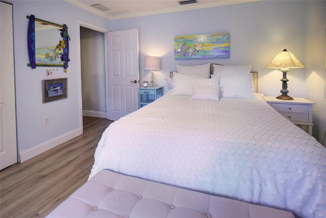 bedroom with hardwood / wood-style flooring and crown molding