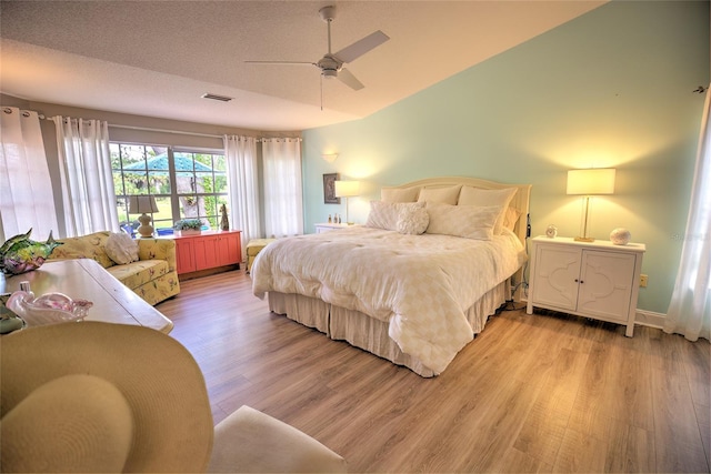 bedroom featuring ceiling fan, a textured ceiling, and light hardwood / wood-style flooring