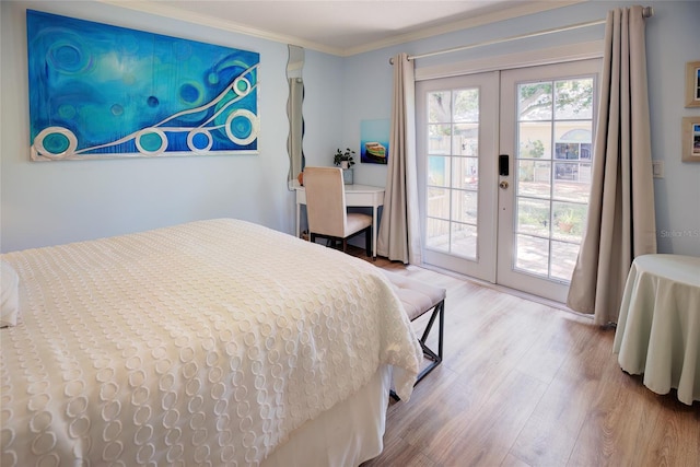 bedroom featuring access to outside, crown molding, french doors, and hardwood / wood-style flooring